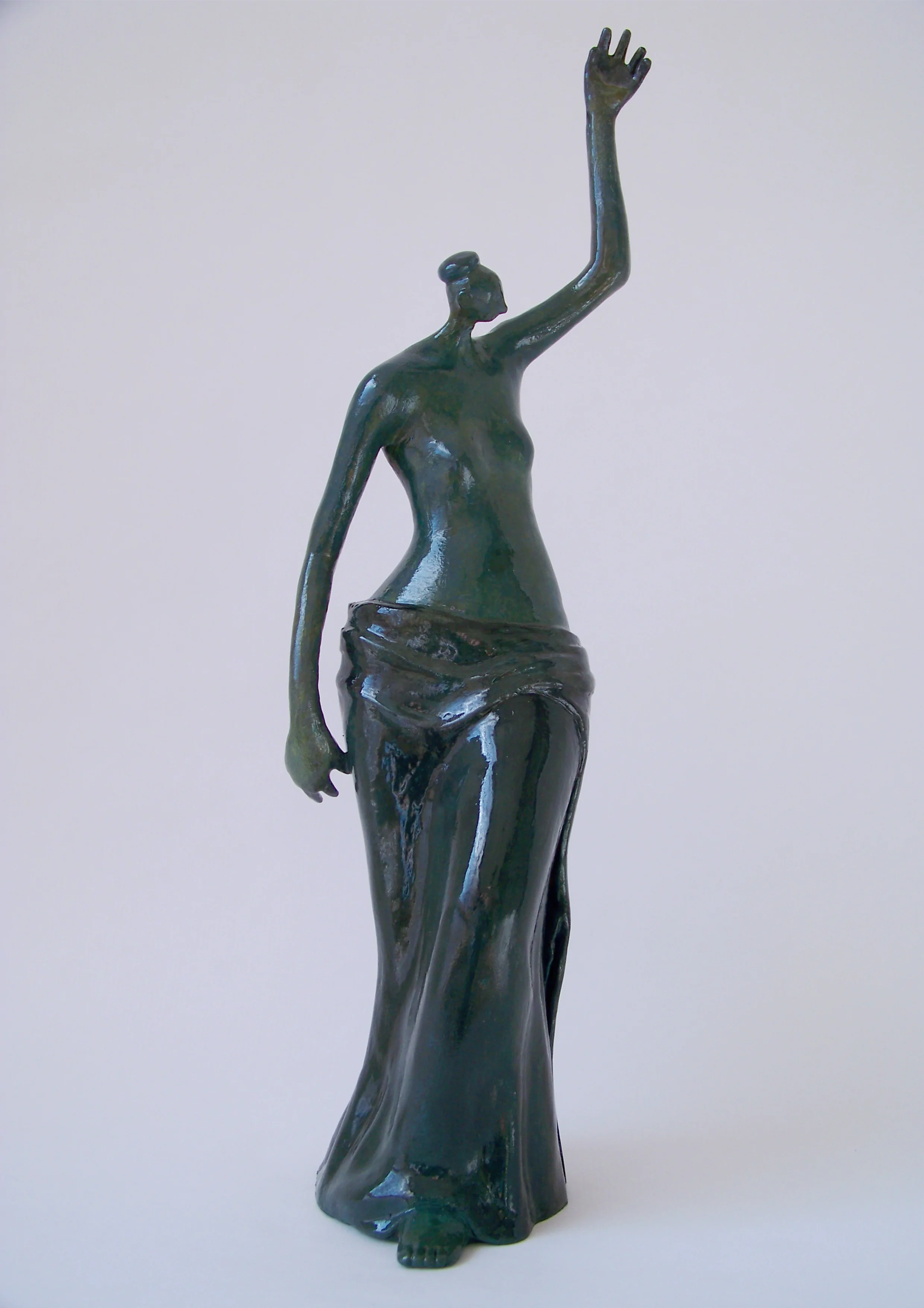 Mujer de pie con un brazo alzado. Tonos verdes. 40x12x12 centímetros. 1,570 kilos