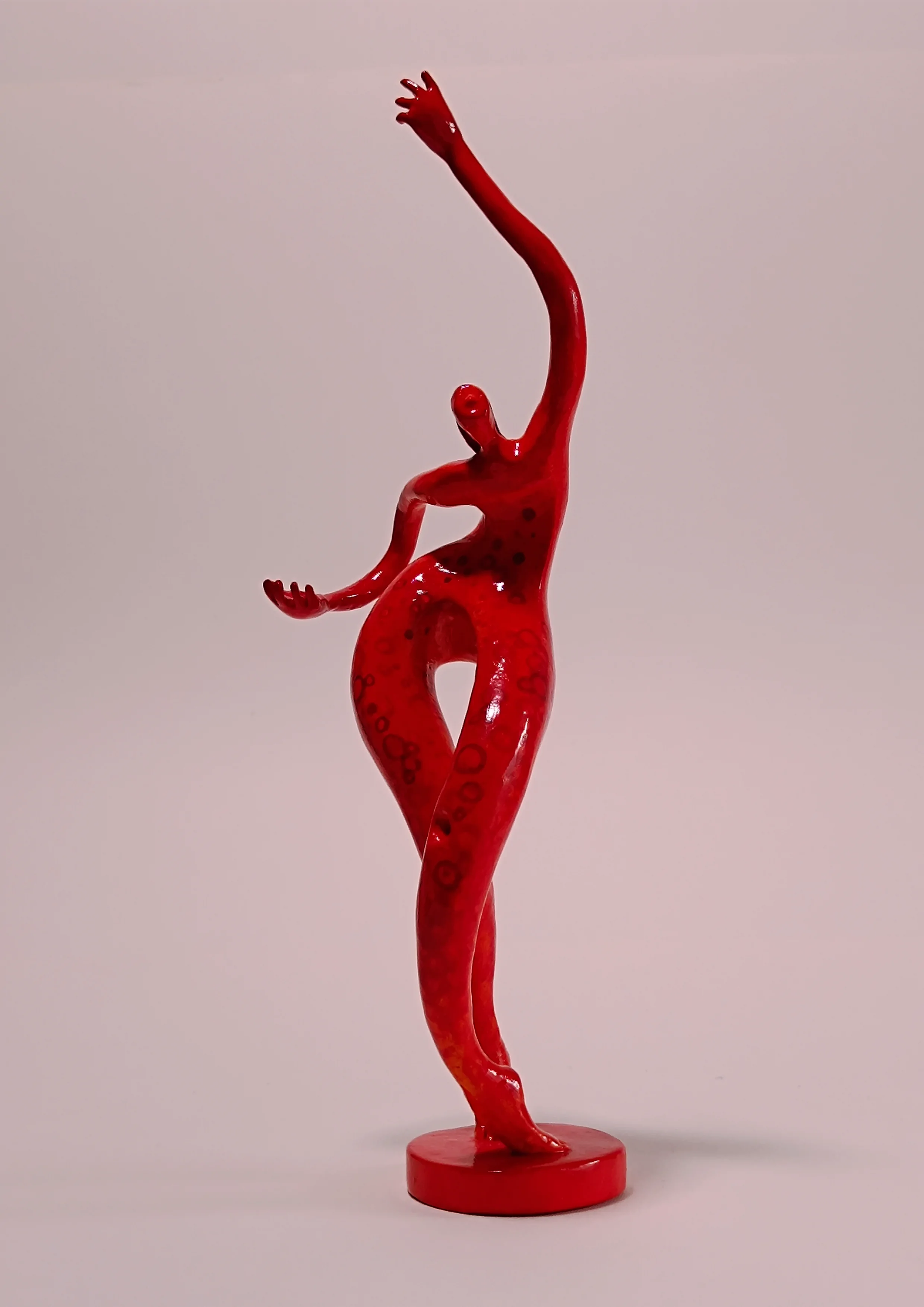 Figura sobre una base con dos apoyos. Tonos rojos. 30x9x8 centímetros, 329 gramos