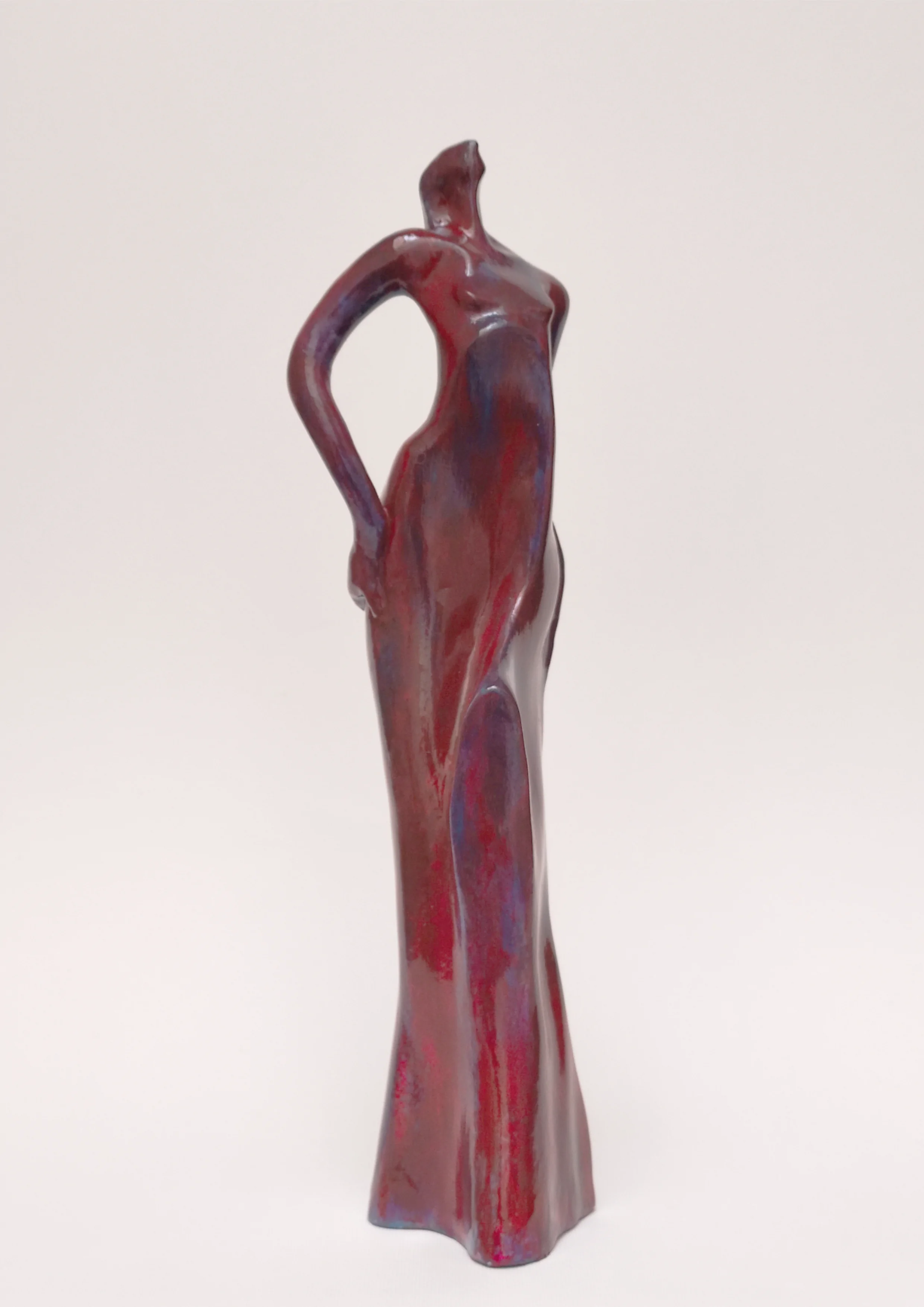 Figura en pie con brazos en jarras. Tonos rojos y azules. 28x8x7 centímetros, 640 gramos