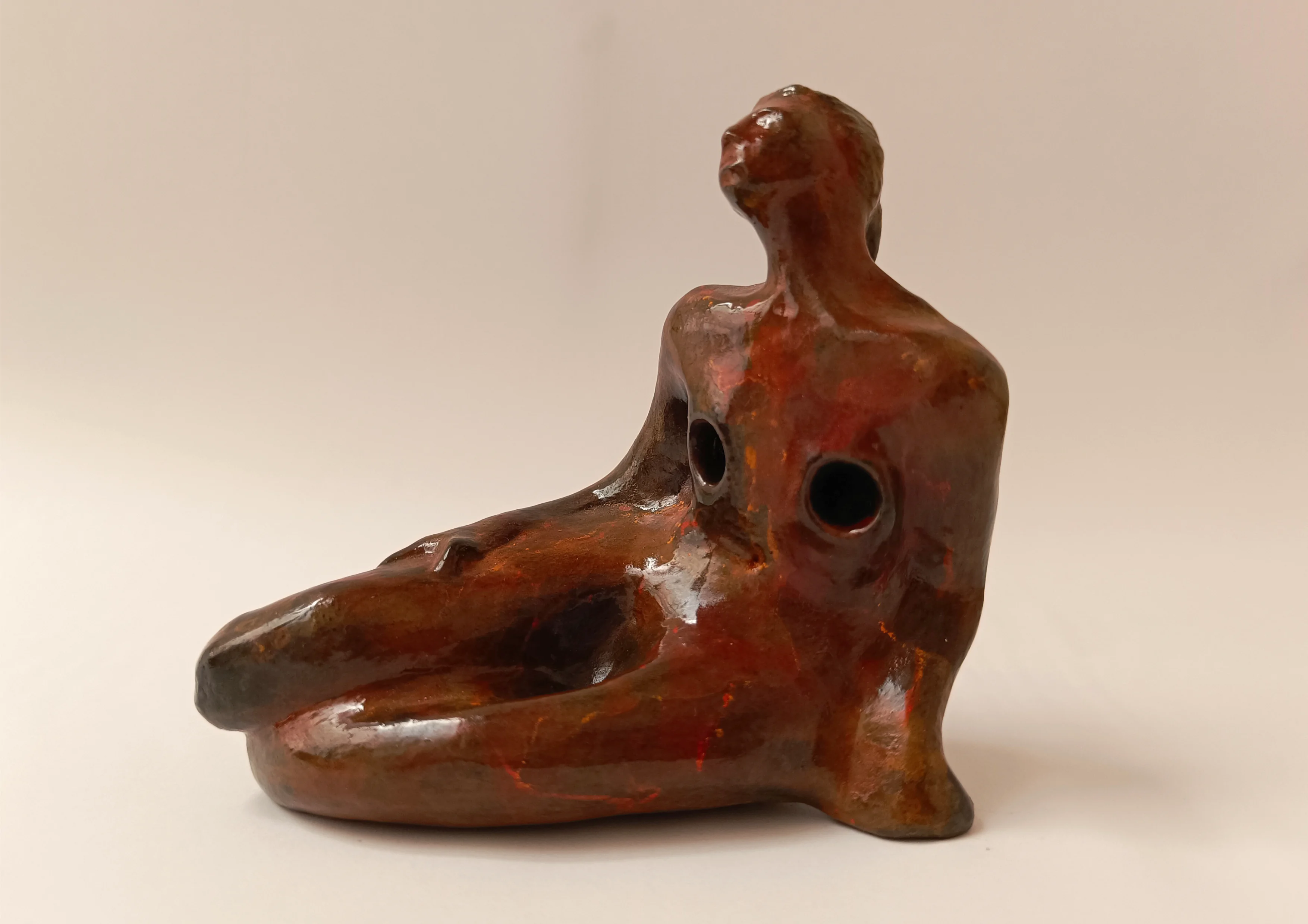 Mujer sentada con una mano apoyada en el suelo. Tonos rojos. 10x10x5 centímetros. 260 gramos